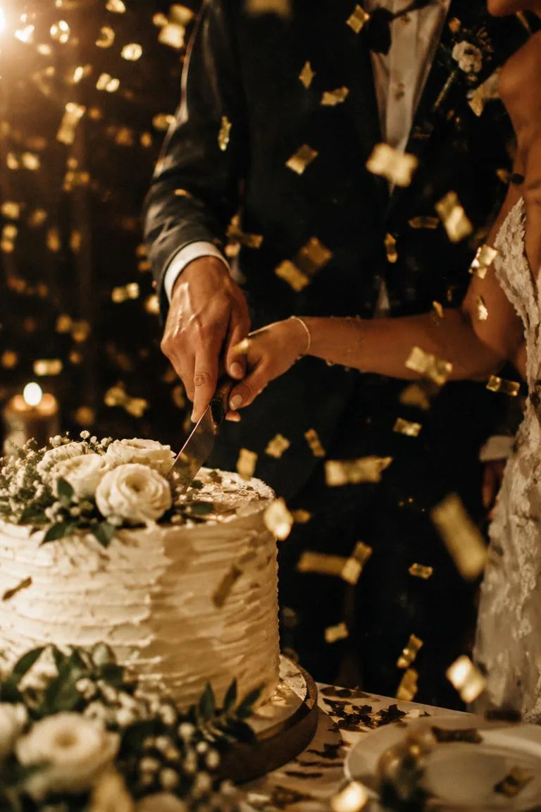 Wedding cake cutting with gold confetti falling